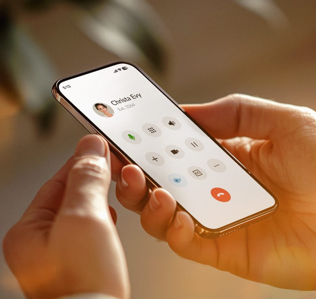 Hands holding a smartphone displaying a dialpad on the RingCentral mobile app