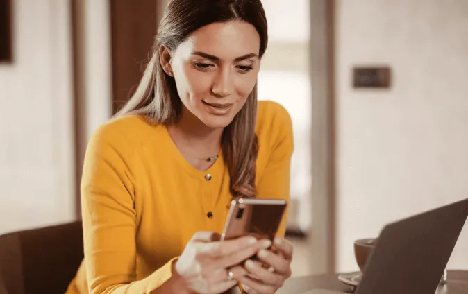 Une femme utilisant l’application RingCentral sur son téléphone portable et sur son ordinateur portable