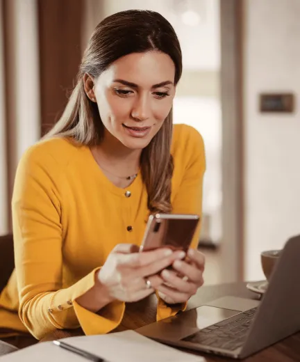Une femme utilisant l’application RingCentral sur son téléphone portable et sur son ordinateur portable