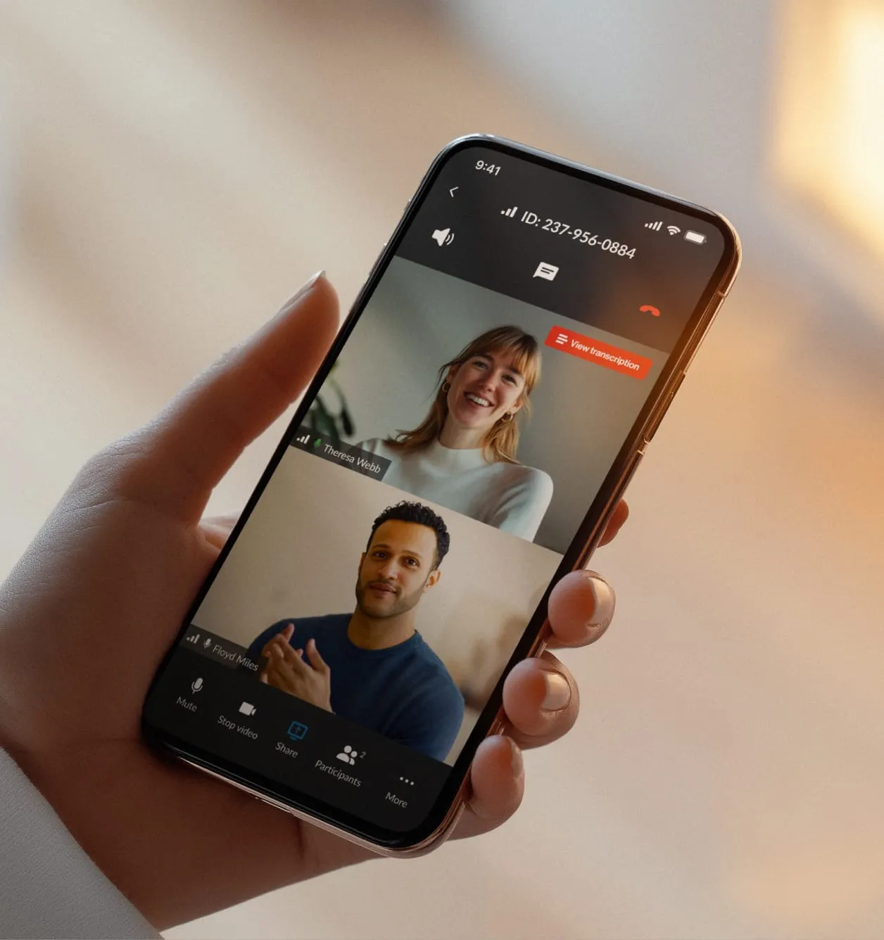 A hand is holding a mobile phone with a RingCentral video call in progress.