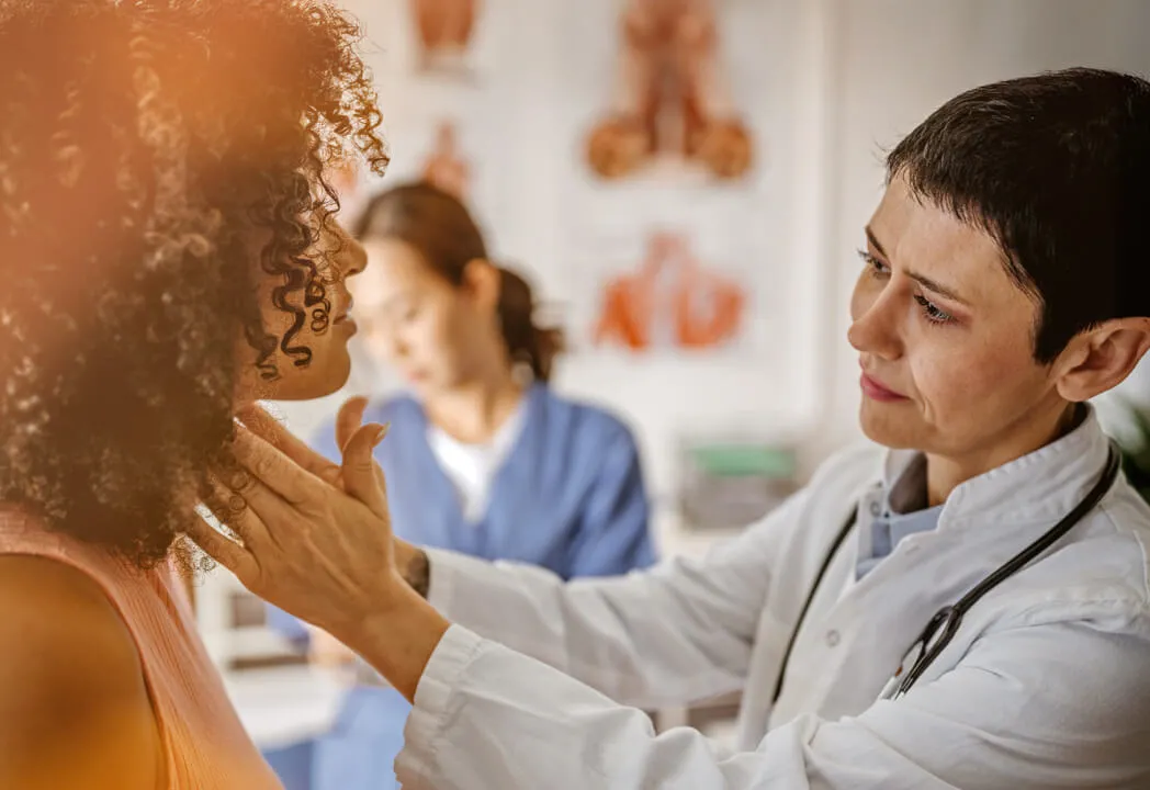 Female doctor reaching out to examine a young woman