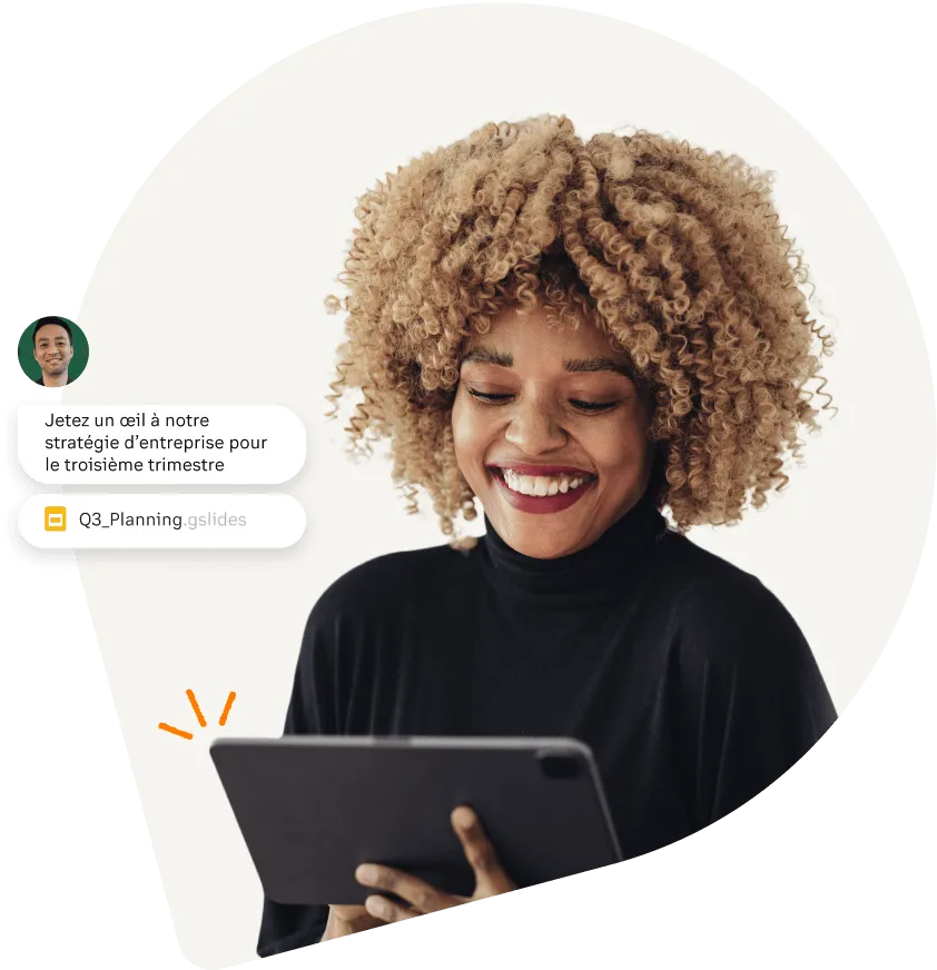 Femme souriant en consultant sur sa tablette un plan d’entreprise envoyé via l’application RingCentral