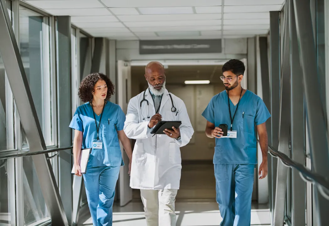 Three medical professionals walking in a hospital