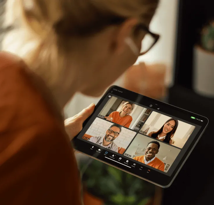 A woman using her tablet for a virtual video meeting with her peers